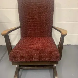 A red rocking chair with a wooden frame and seat.