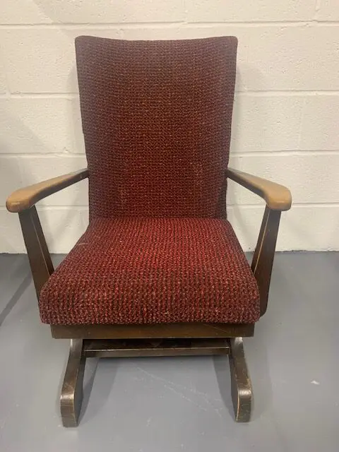 A red rocking chair with a wooden frame and seat.