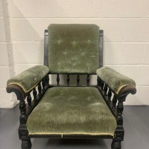 A green chair with a wooden frame and arms.