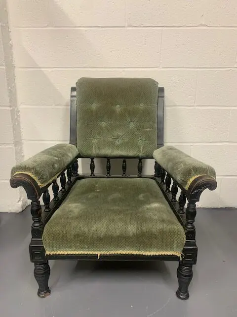 A green chair with a wooden frame and arms.