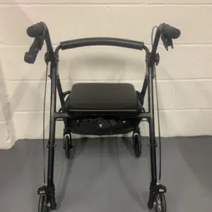 A black walker with wheels and seat on the floor.