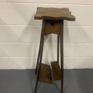 A wooden table with a metal top on a floor.