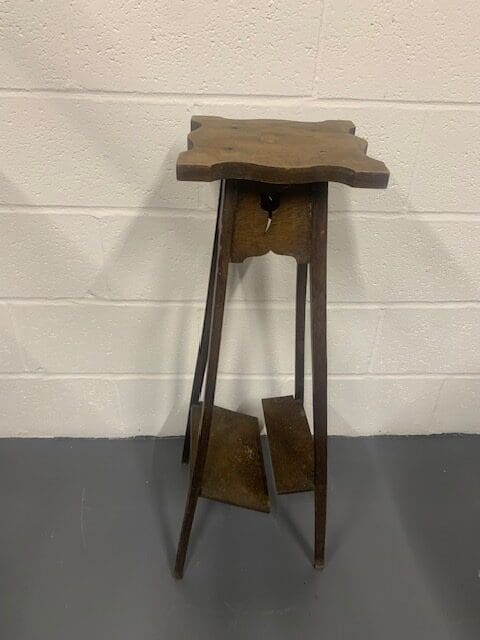 A wooden table with a metal top on a floor.