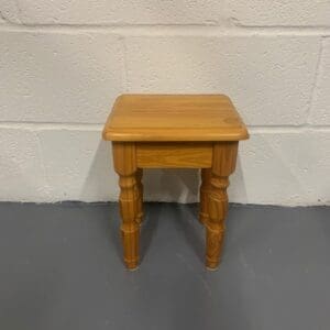 A small wooden table sitting in front of a wall.