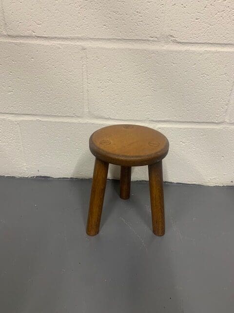 A small wooden stool sitting on the ground.