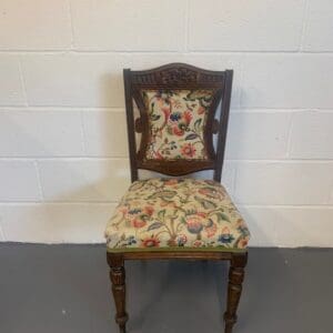 A chair with floral fabric on the seat and back.