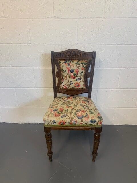 A chair with floral fabric on the seat and back.