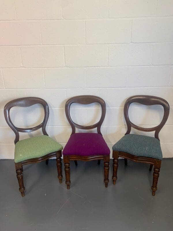 Three chairs are lined up against a wall.