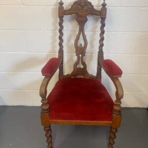 A red chair with a wooden frame and arms.