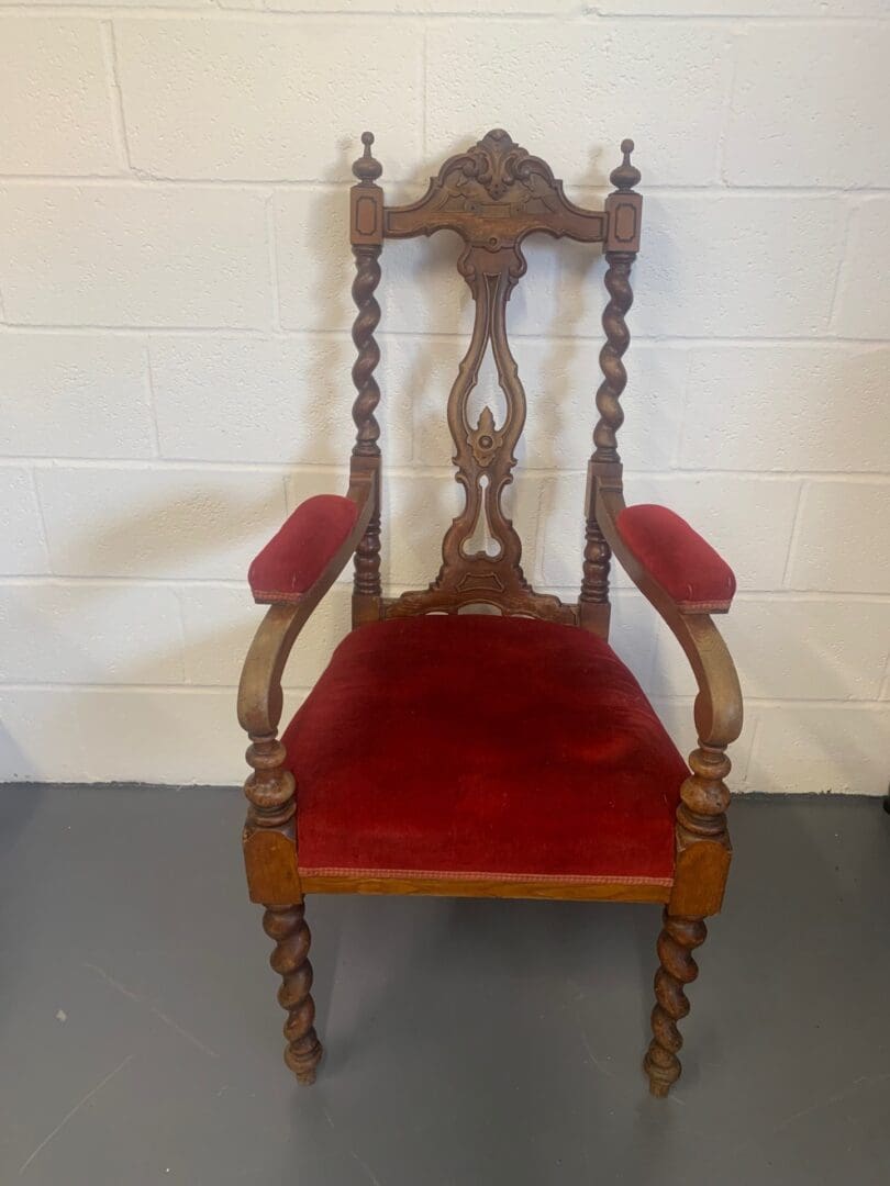 A red chair with a wooden frame and arms.