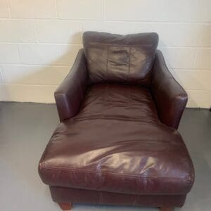 A brown leather chair and ottoman in a room.