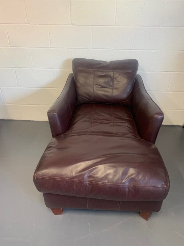 A brown leather chair and ottoman in a room.