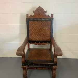 A wooden chair with a black leather seat.