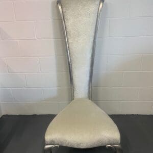 A white chair with silver legs and arms.