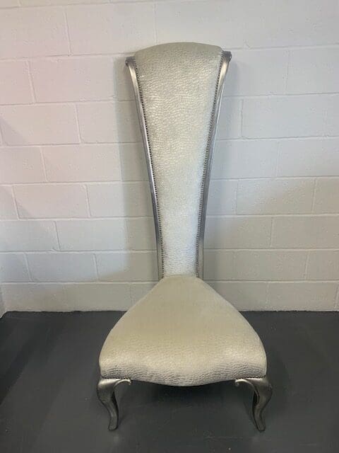 A white chair with silver legs and arms.