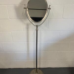 A mirror that is on the floor in front of a wall.