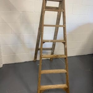 A wooden ladder leaning up against the wall.