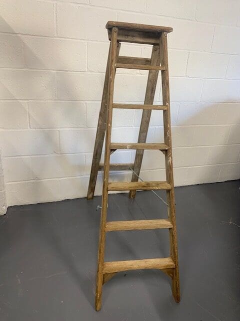 A wooden ladder leaning up against the wall.