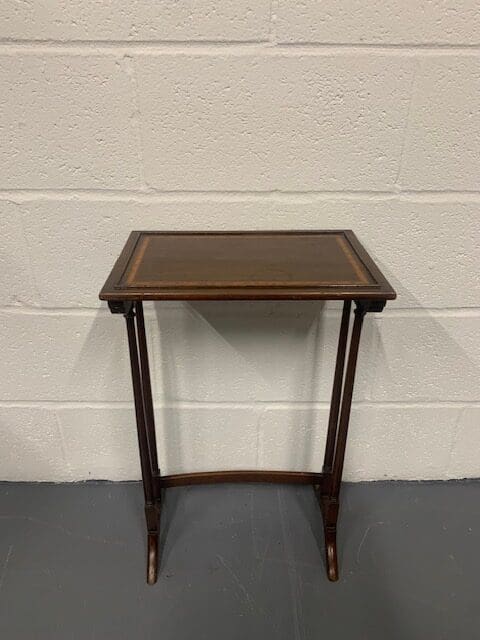 A small table with a brown leather top.