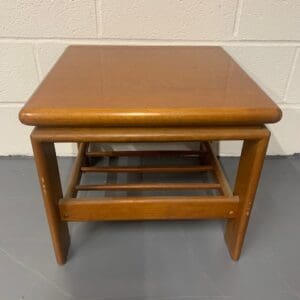 A small wooden table with a shelf underneath it.