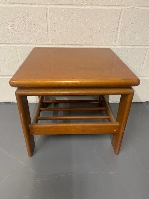 A small wooden table with a shelf underneath it.