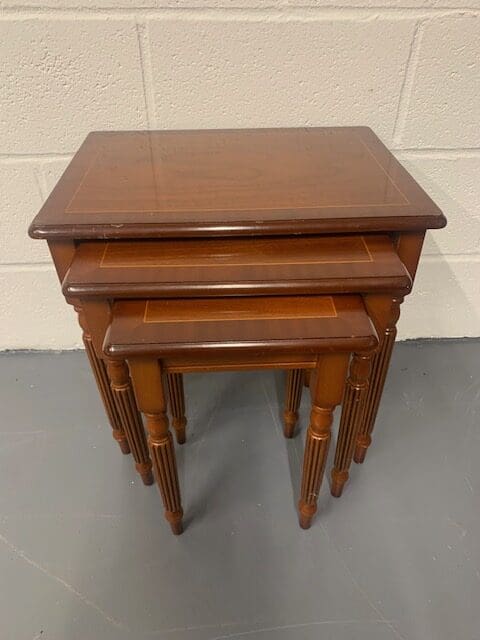 A set of three wooden tables sitting on top of each other.