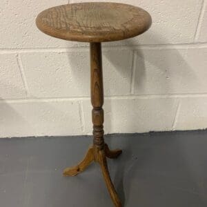 A wooden table with a small round top.