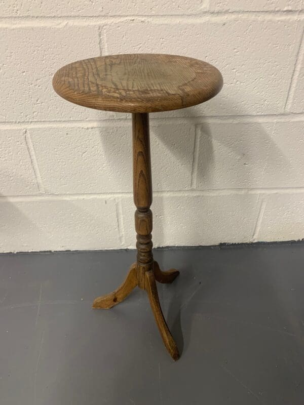 A wooden table with a small round top.