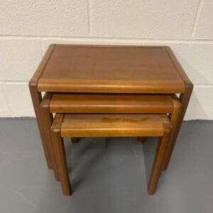 A set of three wooden tables sitting on top of each other.