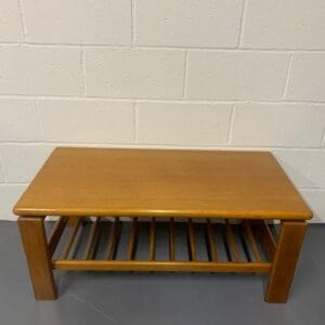 A wooden table with a slatted shelf underneath it.