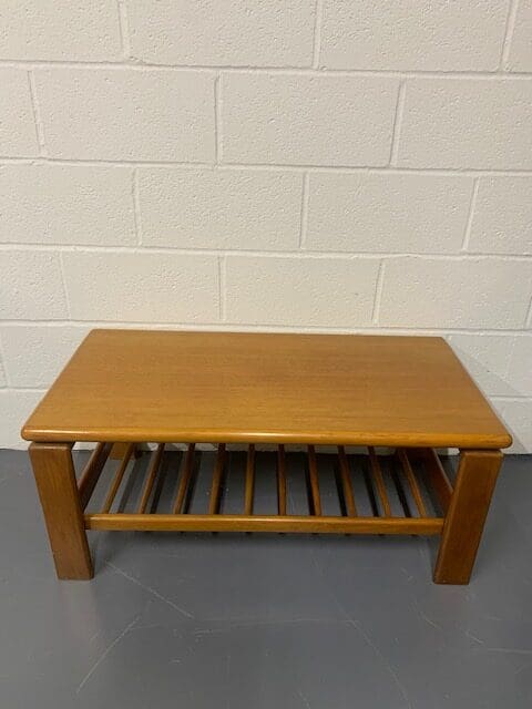 A wooden table with a slatted shelf underneath it.