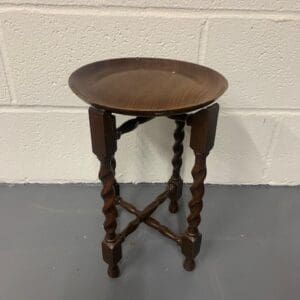 A small wooden table with a metal tray on top.