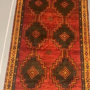 A red and yellow rug with a black border.