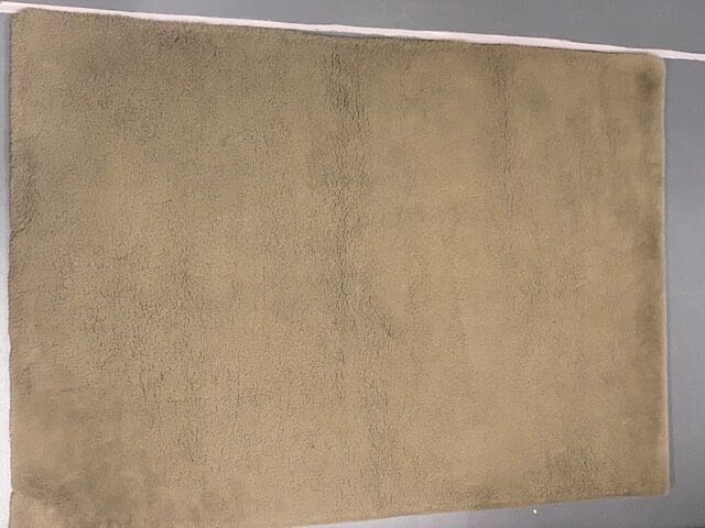 A beige carpet with some brown lines on it