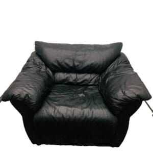 A black leather chair with a pillow on the back.