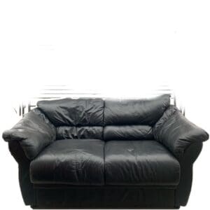 A black leather couch with two pillows on it.