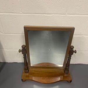 A wooden mirror sitting on top of a table.