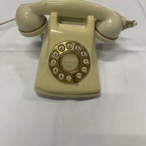 A white phone sitting on top of a bed.