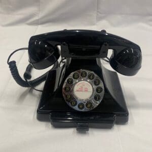 A black phone sitting on top of a white sheet.