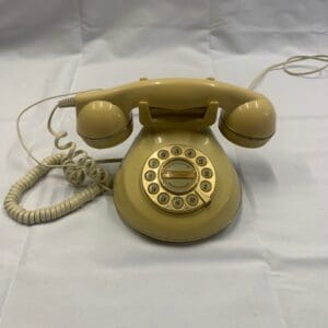 A yellow phone sitting on top of a white table.