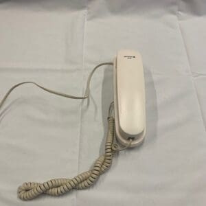 A white phone sitting on top of a bed.