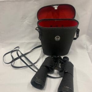 A pair of binoculars sitting in front of a bag.