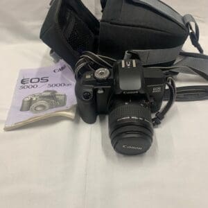 A camera with some papers and a bag