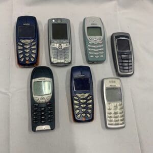 A group of old cell phones sitting on top of a table.