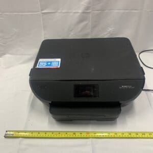 A black printer sitting on top of a white table.