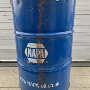 A barrel of oil sitting on top of the ground.