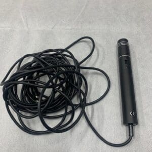 A black microphone and some black cords on top of a table.