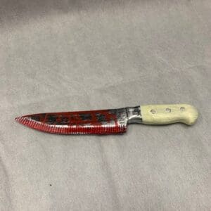 A knife with red handle and white ceramic blade.