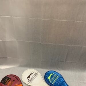 Three different colored condoms sitting on top of a bathtub.