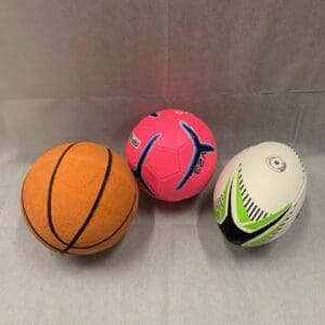 Three different balls are sitting on a table.